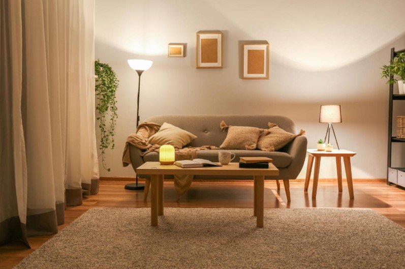 A small living room illuminated by a floor lamp and table lamp